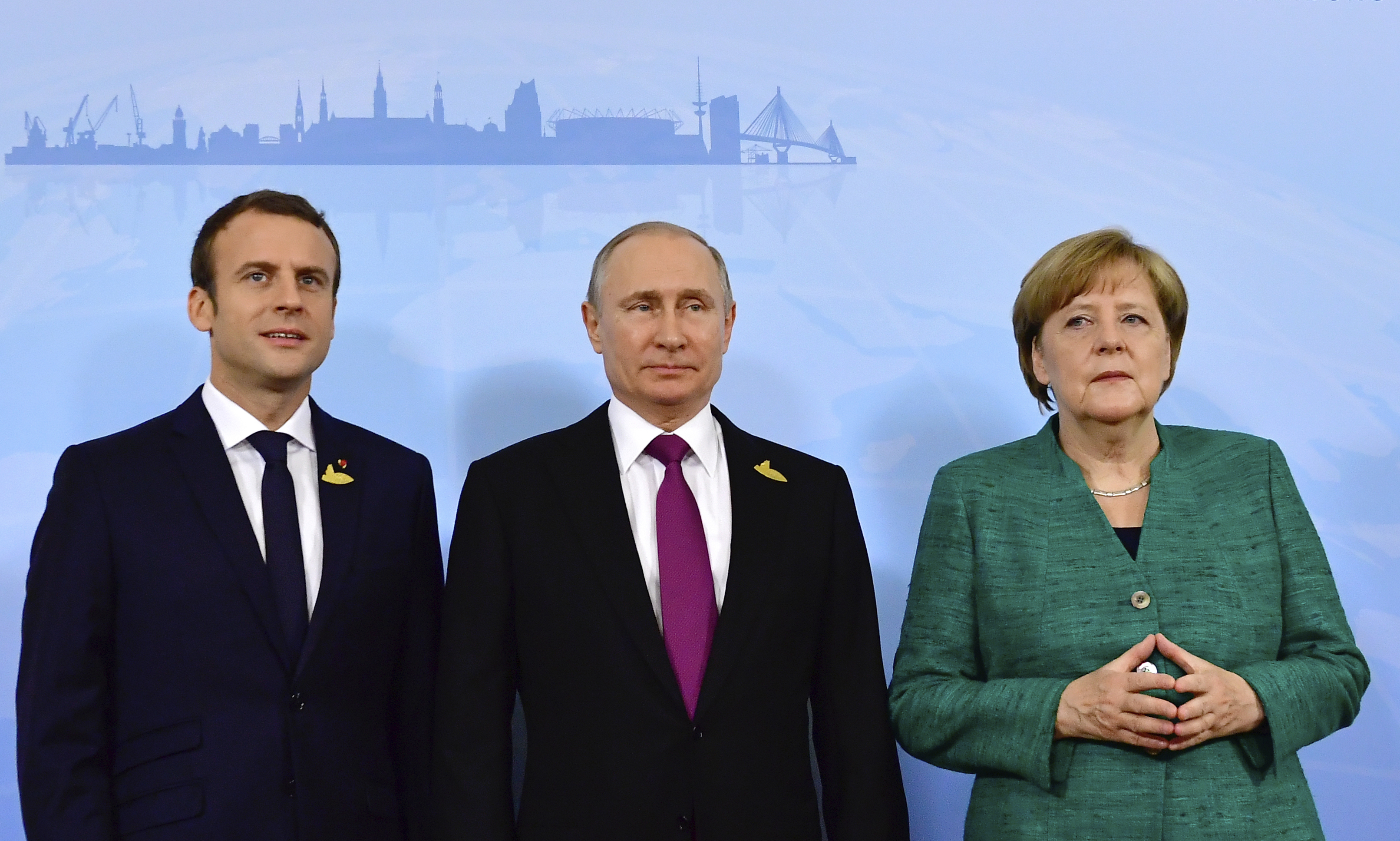 French President Emmanuel Macron, left, Russia’s President Vladimir Putin, center, and German chancellor Angela Merkel