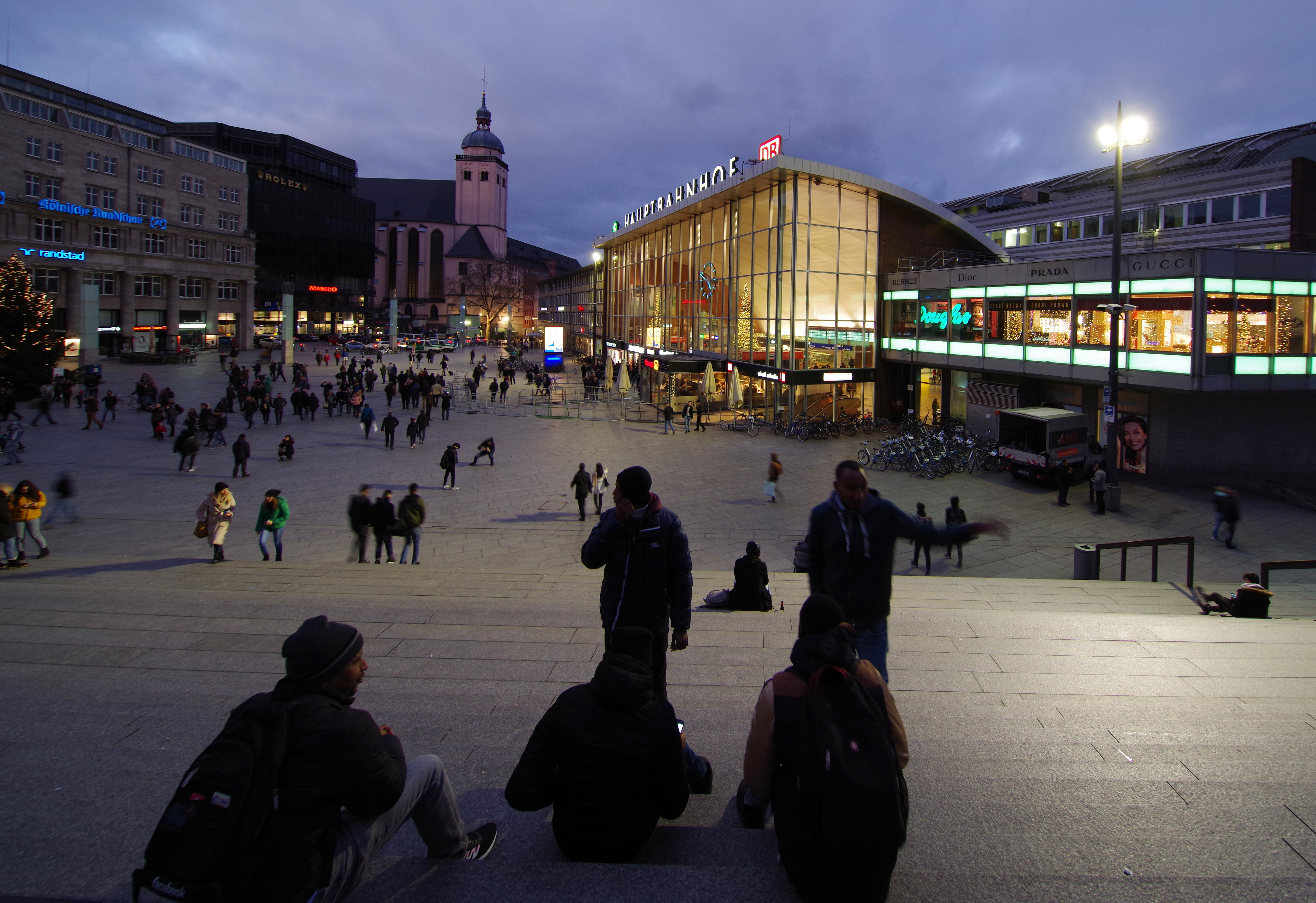 Junge Migranten sitzen am 25.12.2017 auf einer Treppe vor dem Hauptbahnhof in Köln (Nordrhein-Westfalen). In der Silvesternacht 2015/2016 waren Frauen auf dem Bahnhofsvorplatz massenhaft sexuell bedrängt und teils beraubt worden – überwiegend von Gruppen alkoholisierter junger Männer aus Maghreb-Staaten.