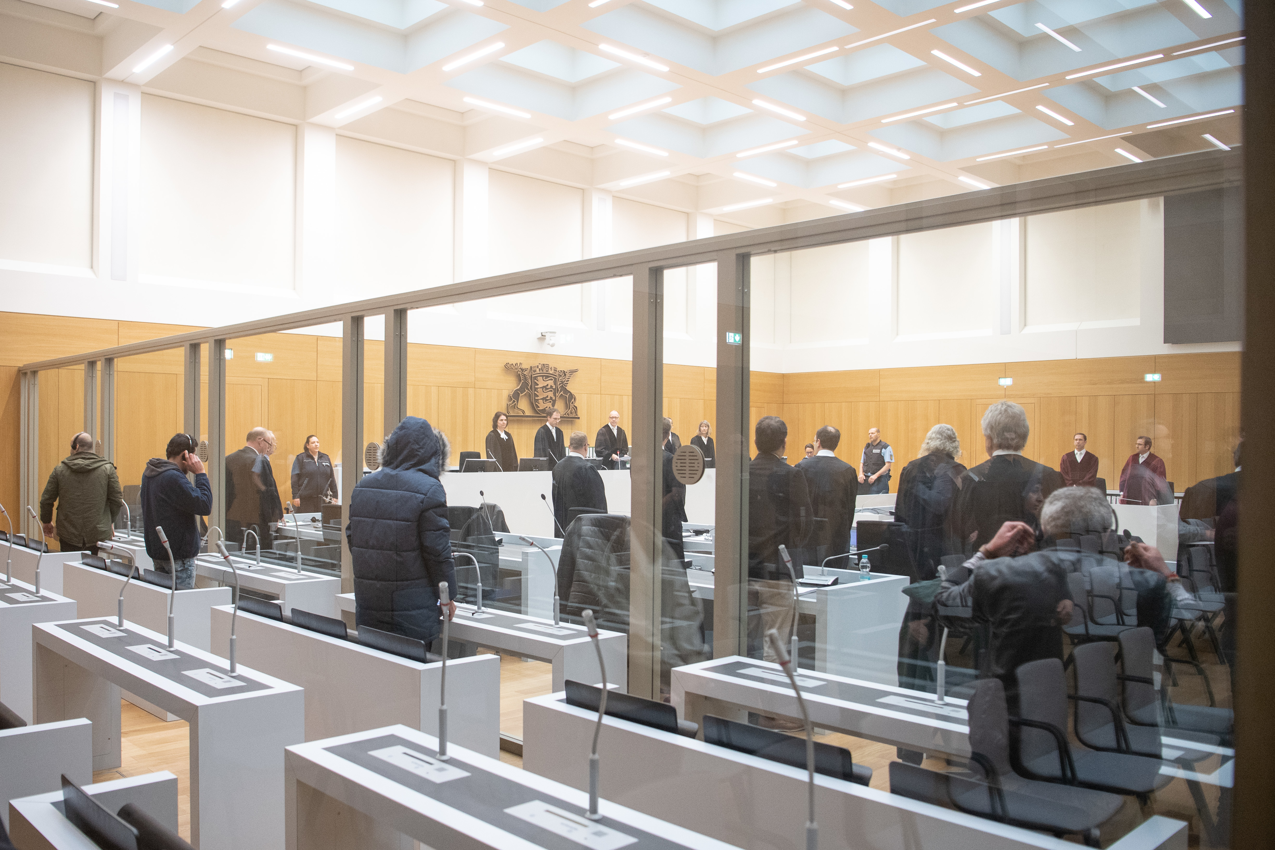 Terrorprozess in Stuttgart, Die Angeklagten stehen vor der Urteilsverkündung im Prozess gegen vier mutmaßliche Anhänger der Terrorgruppe Dschabhat al-Nusra im Gerichtssaal.