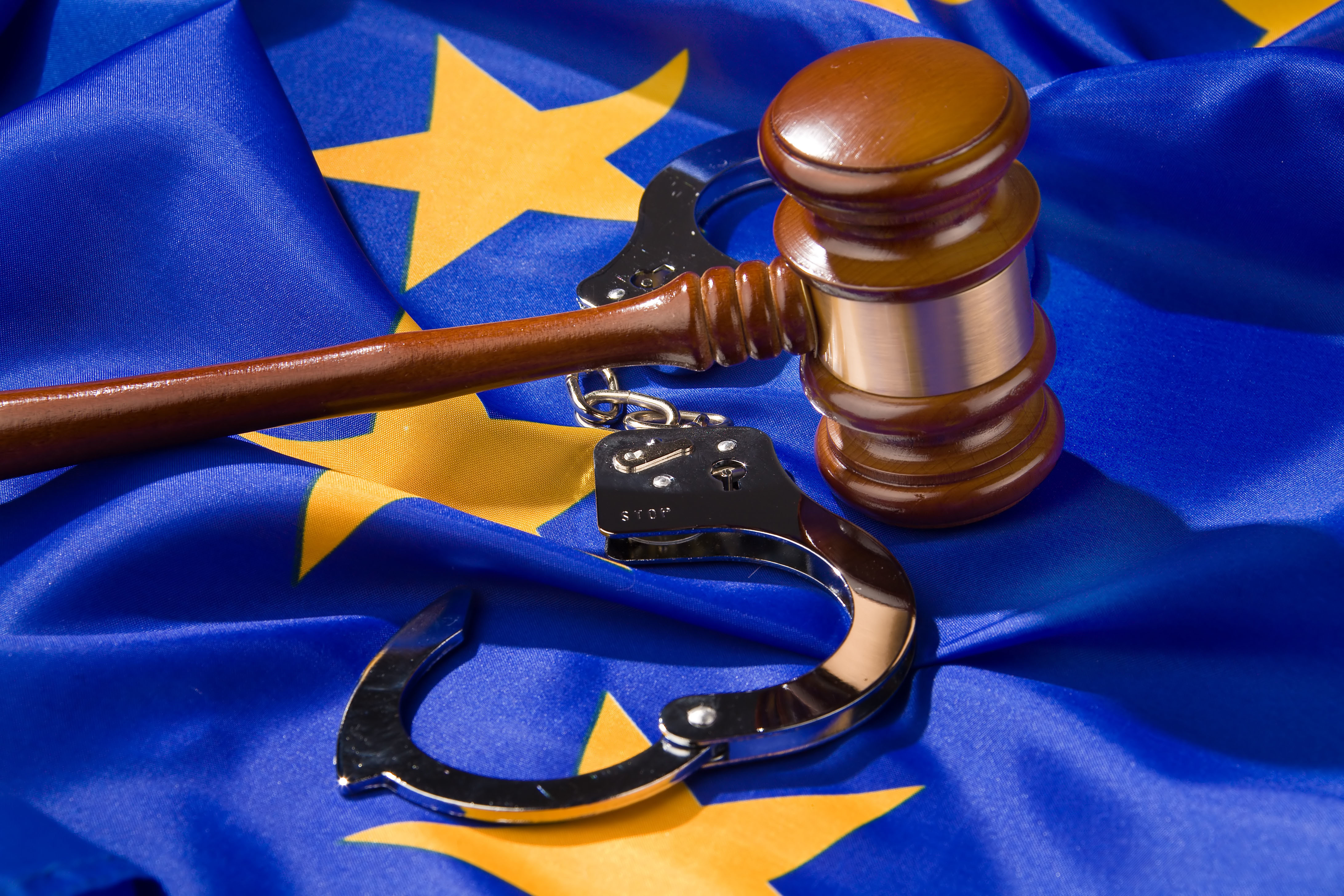Symbolbild: Richterhammer, EU-Fahne und Handschellen